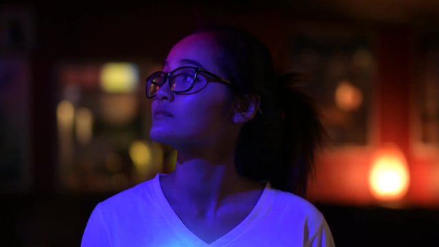 Young Beautiful Asian Woman With Eyeglasses Looking Around In The Club And Smiling