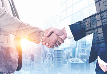 Businessmen shaking hands in morning city