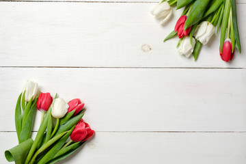 Tulips flowers on white wooden background. Top view, frame, border, corner. Greeting card for womans day, mothers day, birthday, easter or spring holiday. Rustic background, above vie