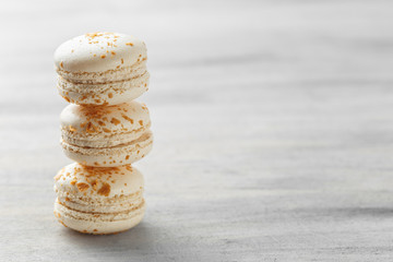 Stack of white praline macarons on grey background