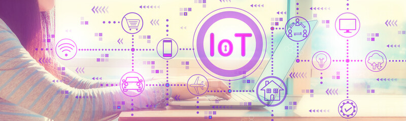 IoT theme ith woman working on a laptop in brightly lit room