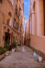 Fototapeta na wymiar Narrow street in Genova city and the blue sky
