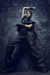 Young woman in brutal futuristic clothes on background 