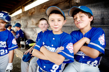 Little league players (8-9, 10-11) goofing around in dugout 