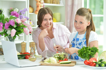 Obraz na płótnie Canvas Portrait of funny girls preparing fresh salad