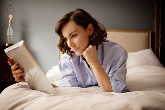 Woman using tablet in bed 