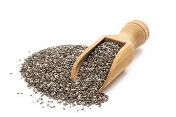 Pile or heap of chia seeds and a small wooden scoop seen obliquely from above and isolated on white background