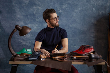 young designer looking for the inspiration, close up photo. shoemaker is on the ninth cloud
