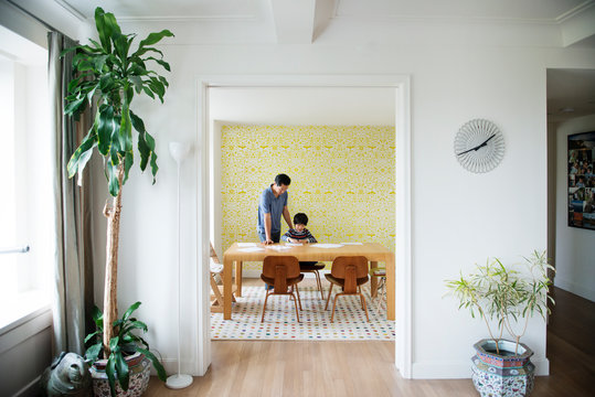 Father helping son doing homework at home