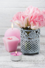 Fresh pink tulip flowers and lit candles