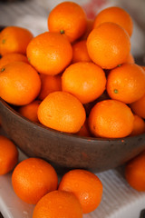 A lot of oranges in a large wooden bowl. Healthy food and lifestyle