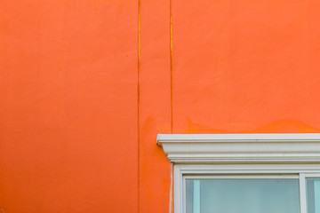 Orange wall with window frame corner and copy space space for text.