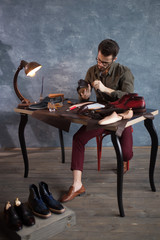 awesome pleasant man working in the atelier in the room with a lamp, full length photo