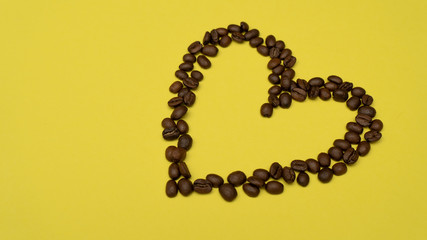 Heart of coffee beans on the right on a yellow background
