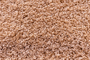 Texture of a beige carpet with a large nap.