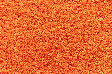 Texture of a orange carpet with a large naps.