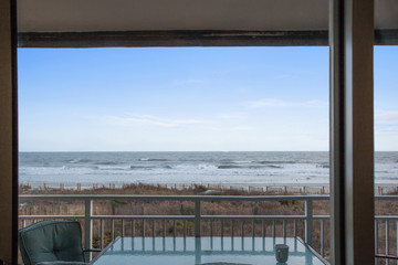 View of Beach from Apartment Balcony Empty with Table and Armchairs