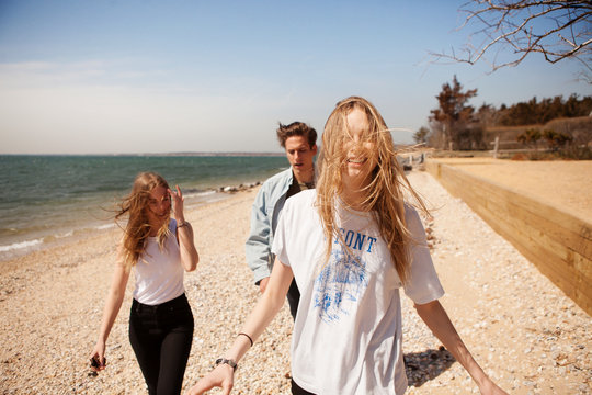 Young people walking on beach 