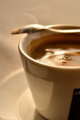 cup of coffee with cream on wooden background