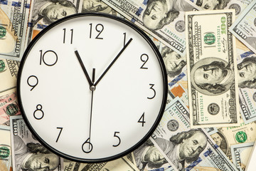 One hundred dollar bills and a white big clock, concept, time is money background