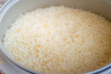 Cooked jasmine rice in the electric rice cooker pot and ready to serve and eat.