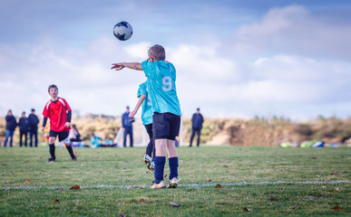 Young soccer player throwing in the ball during the game
