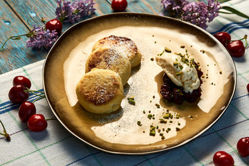 Homemade Cottage cheese pancakes, syrniki on rustic wooden table, close-up
