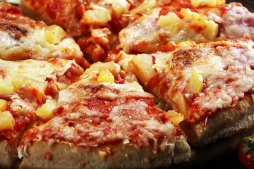 Delicious pizza with pineapple, ham slice, bacon slice, mozzarella cheese, pizza sauce on rustic background for fast food and ready to eat concept