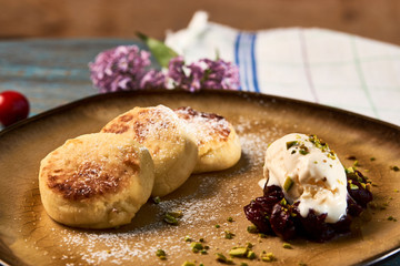 Homemade Cottage cheese pancakes, syrniki on rustic wooden table, close-up