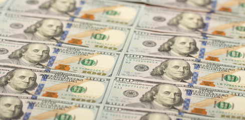 Blurred background full of 100 us dollars. Business and finance. selective focus.