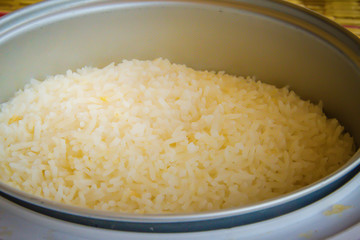 Cooked jasmine rice in the electric rice cooker pot and ready to serve and eat.