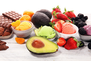 Set of ice cream scoops of different colors and flavours with berries, chocolate and fruits.