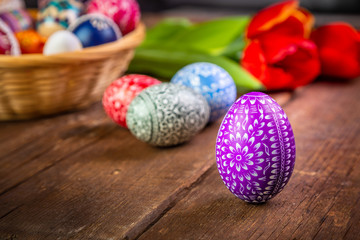 Easter eggs with tulips on weathered wooden background