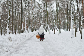 Fototapeta na wymiar little girl in shawls in winter, looking for snowdrops