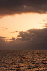 Sky, sunset, ocean, sea, water, ocean waves, clouds, glowing light, colorful, calming, vertical image