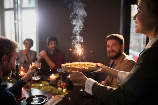 Woman carrying cake during dinner party 
