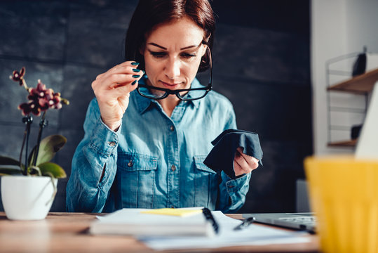 Woman Cleaning Eyeglasses At Her Office