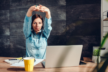 Business woman stretching arms in the office