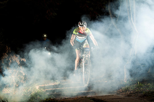 Mature man cycling in park at night  