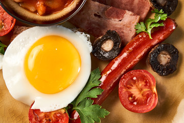 Full English breakfast with bacon, sausage, fried egg, baked beans
