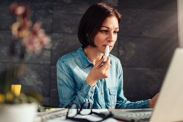 Woman applying lip balm at work