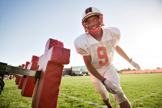 Young football player practicing in football field  - Powered by Adobe