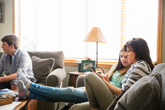 Mother with children (16-17) relaxing in living room 