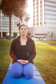Woman doing yoga on lawn 
