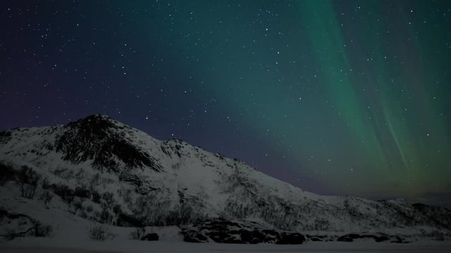 Northern Lights, polar light or Aurora Borealis in the night sky over the Lofoten islands in Northern Norway time lapse.