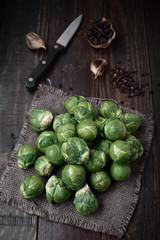 bunch of raw brussels sprouts on rustic wood with natural light