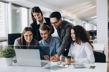 Collaboration is a key to success. Young business people discussing something while looking at the computer monitor together in the office.
