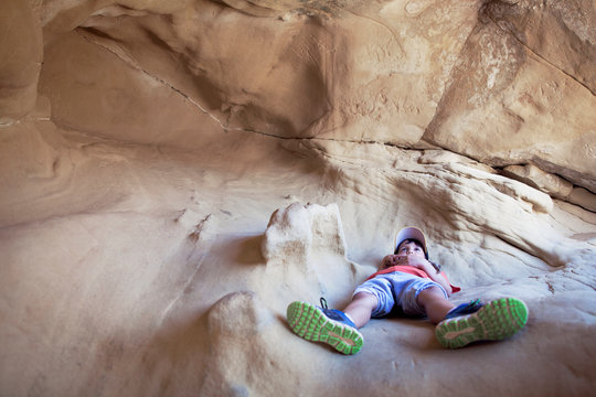 Boy lying in cave 