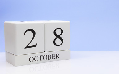 October 28st. Day 28 of month, daily calendar on white table with reflection, with light blue background. Autumn time, empty space for text