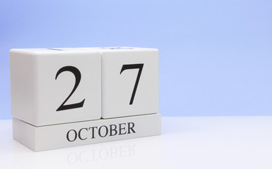 October 27st. Day 27 of month, daily calendar on white table with reflection, with light blue background. Autumn time, empty space for text